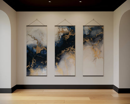 Three abstract wall hangings with blue and gold patterns on a beige wall.