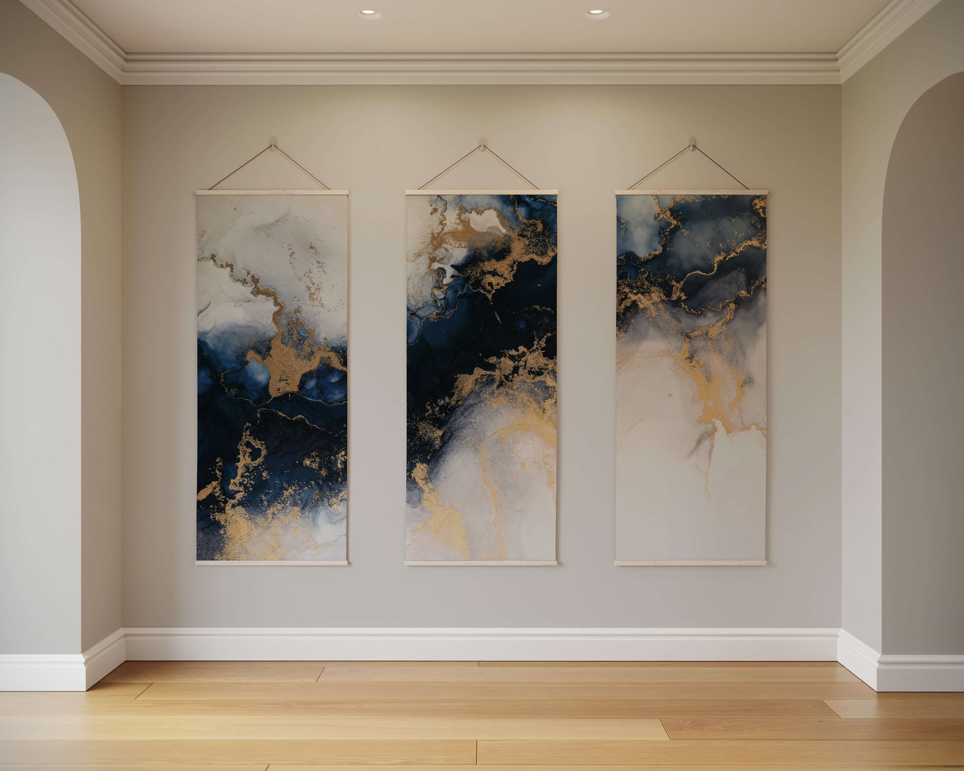 Three abstract wall hangings with blue, gold, and white colours on a beige wall.