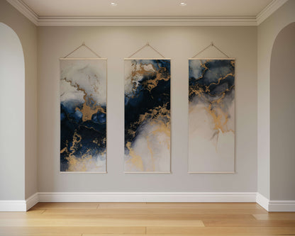 Three abstract wall hangings with blue, gold, and white colours on a beige wall.