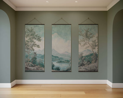 Three landscape paintings hanging on a wall in a room with wooden flooring.