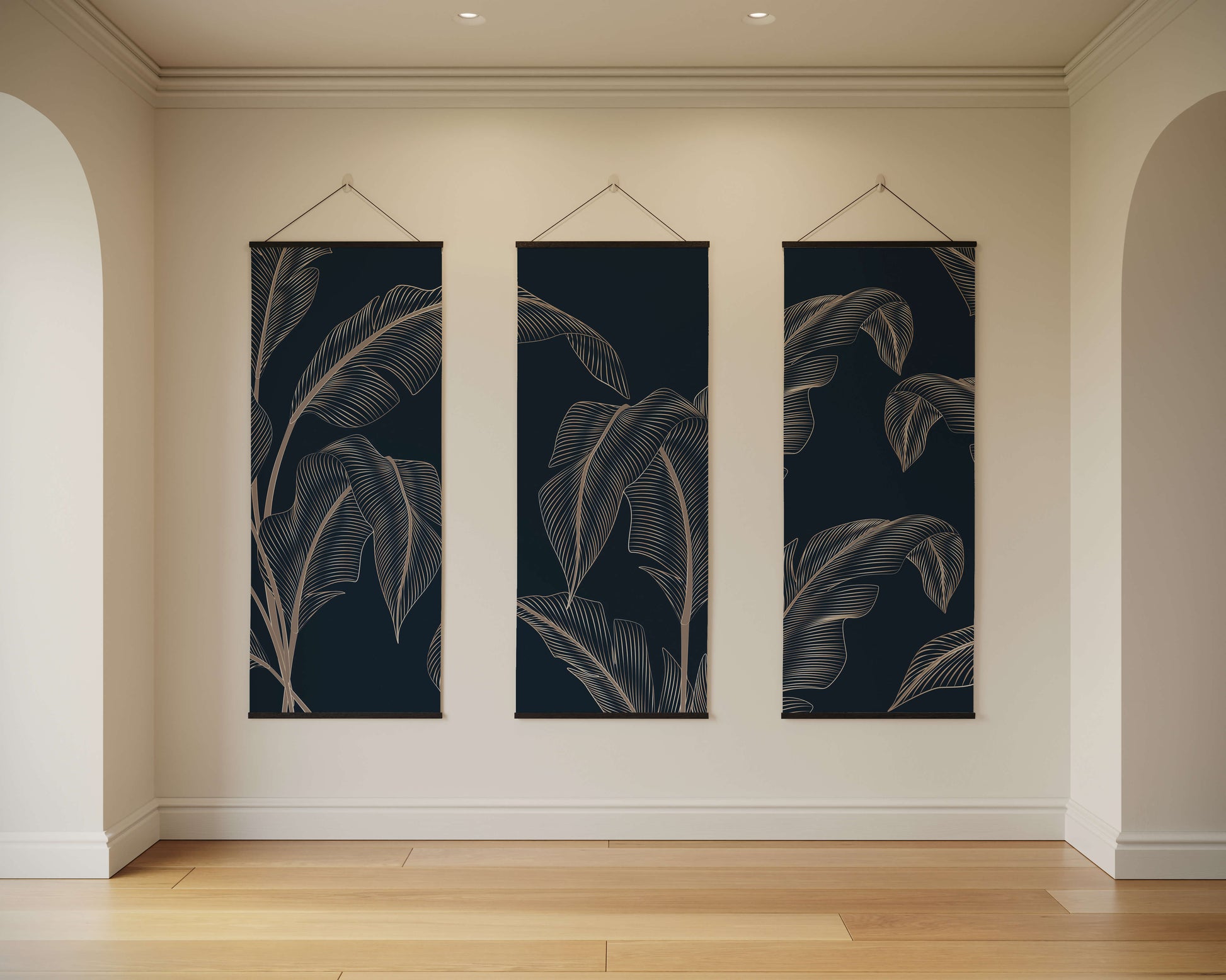 Three vertical wall art pieces with leaf patterns hanging on a beige wall.