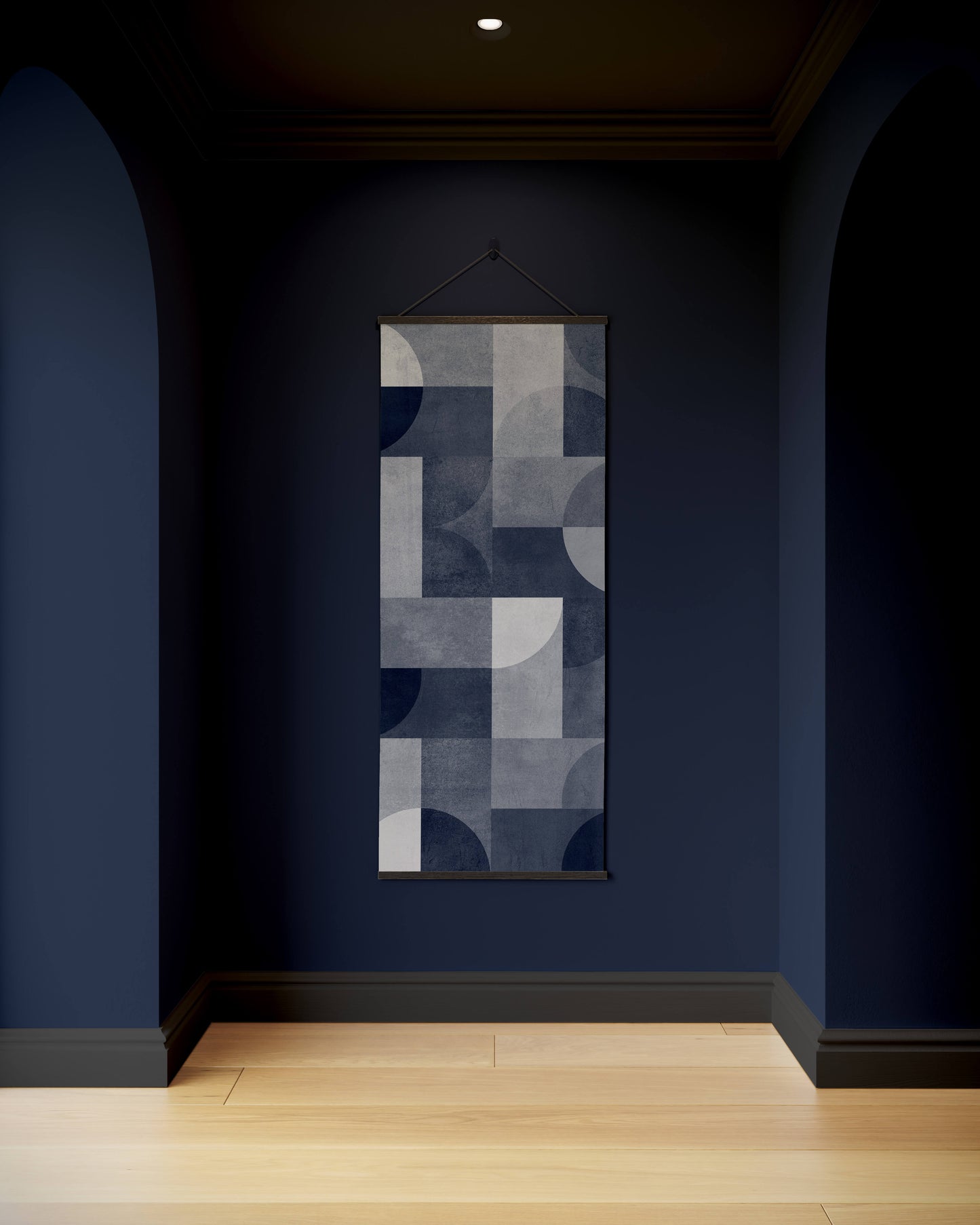 Abstract wall art hanging on a dark blue wall in a room with wooden flooring.