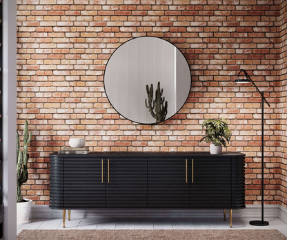 Black dresser with gold accents against a brick wall