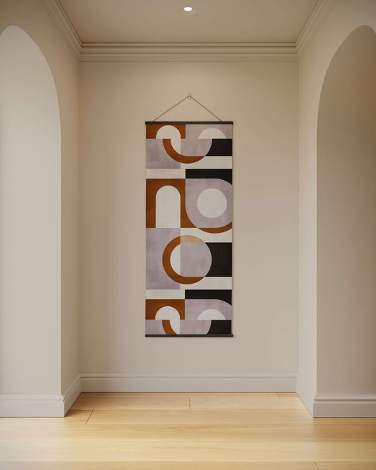 Abstract wall tapestry hanging on a plain wall in a room with wooden flooring.