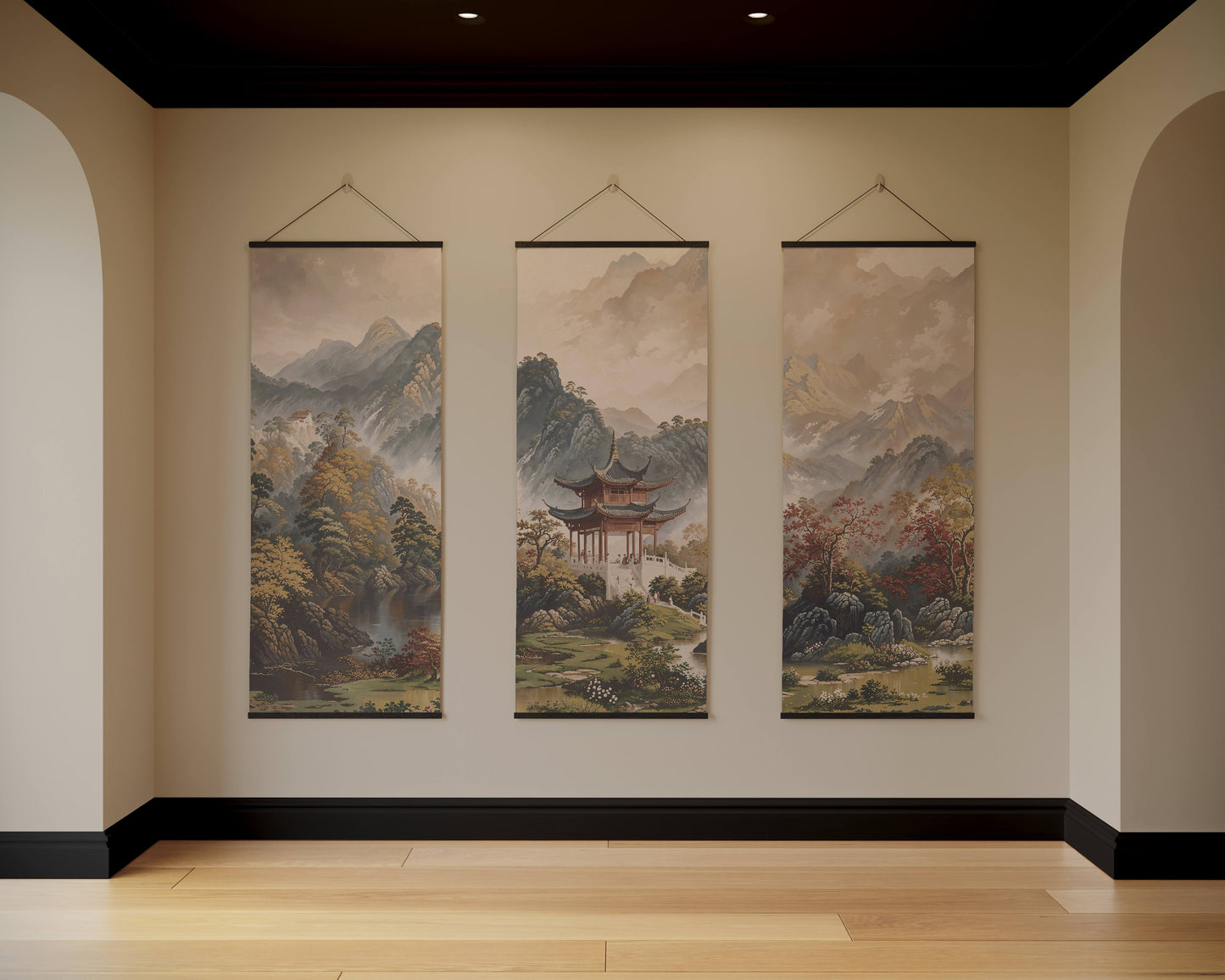 Three hanging landscape paintings on a wall with a neutral colour scheme.